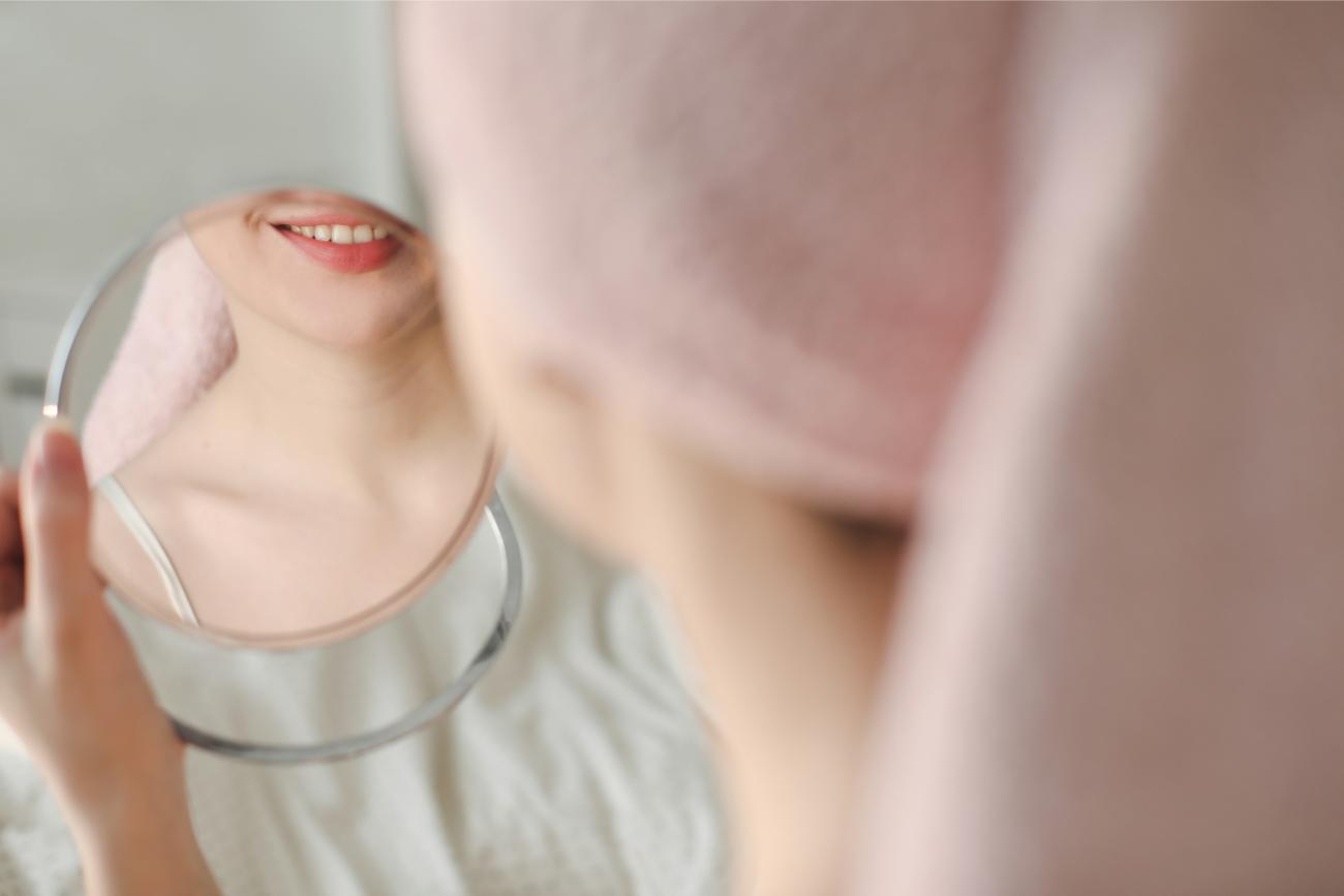 Mujer sonriendo en un espejo